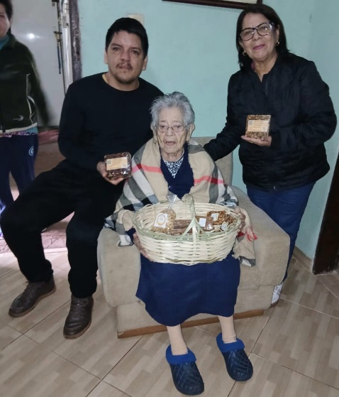 Doña María Bóveda de Pisciotta con su hija Estela y su nieto José, sosteniendo dulces de maní